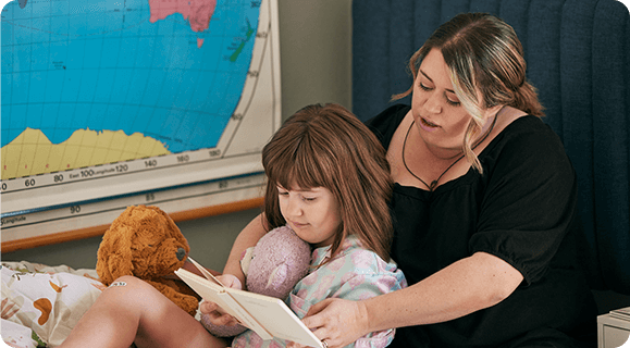 EPIDIOLEX Safety Profile Overview | Child sitting and smiling with adults outdoors in a yard