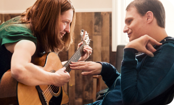 EPIDIOLEX Patient Living with LGS | Woman Playing Guitar for Smiling Man